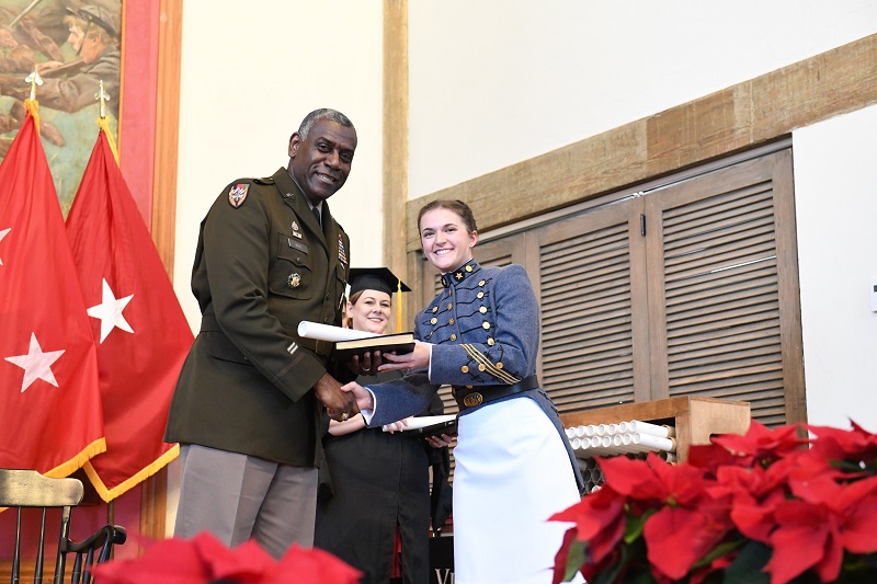 Superintendent Maj. Gen. Cedric T. Wins '85 congratulates a female graduate of 鶹ŮԱ Institute as he hands her her diploma during the December 2023 commencement ceremony.